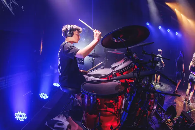 Batería tocando en directo bajo las luces azules